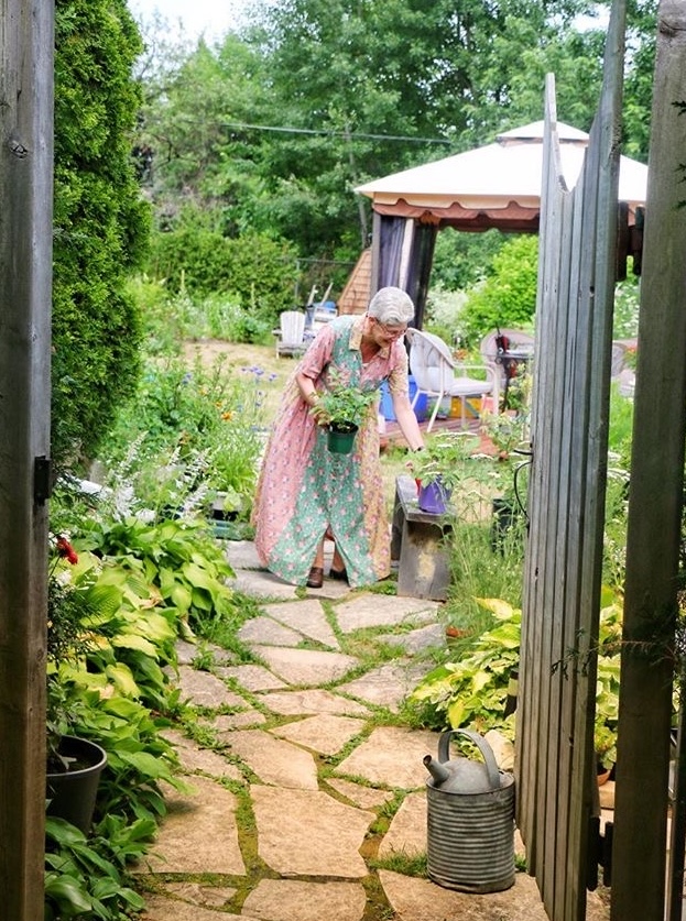 Rosalind's Garden Blooms tending to the summer garden with view throught the gate